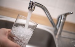 File: A man holds a glass under a running tap. AFP/DPA/Marius Becker