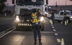 File: A South Africa Police Service's officer (SAPS) sets up a road block.