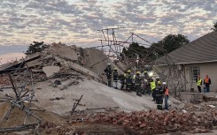 Rescue workers are seen at the scene of a collapsed building in George on May 7, 2024.