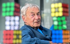 Hungarian inventor Erno Rubik sits next to several Rubik's Cubes. AFP/Attila Kisbenedek