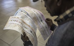 File: An early voter, checks his ballot papers at the Yeoville Recreation Centre in Johannesburg on May 27, 2024. 