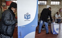A voter marks her ballot papers in a voting booth. AFP/Phill Magakoe