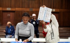 An IEC official holds up a marked ballot during the vote counting process. AFP/Gianluigi Guercia