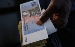 A customer receives the new $10 ZiG, short for Zimbabwe Gold, note as change from a cashier in a leading supermarket in Harare on April 30, 2024.