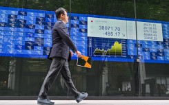 A man walks past an electronic board showing the numbers during afternoon trade on the Tokyo Stock Exchange. AFP/Richard A Brooks