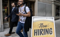 People walk past a restaurant, with a hiring sign outside, in Washington, DC. AFP/Andrew Caballero-Reynolds