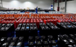 File:  an employee working at a factory that produces lithium battery for export. AFP/China Out