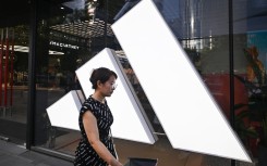 A woman walks past an Adidas store at a mall in Beijing. AFP/Pedro Pardo