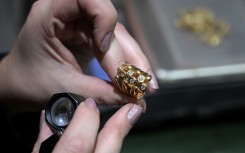 An appraiser examines a gold ring at a gold dealership in Buenos Aires. AFP/Juan Mabromata