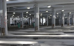 File: Commuters wait for transport at a deserted taxi rank. AFP/Gianluigi Guercia