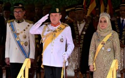 Malaysia's King Sultan Ibrahim Iskandar (C) saluting for the national anthem next to Queen Raja Zarith Sofiah. AFP/Malaysia's Department of Information