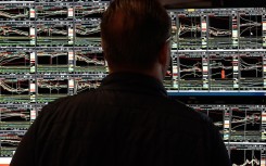 File: A trader looking at stock market graphs. AFP/Timothy A Clary