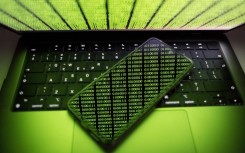 Binary code is being displayed on a smartphone and on a computer screen in Chania, Greece, on August 9, 2024.