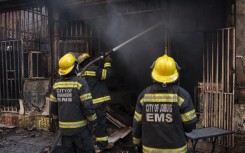 Firefighters extinguish a fire that broke out in a building in Johannesburg. AFP/Emmanuel Croset