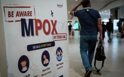 A passenger walks past a banner informing about MPOX at Soekarno-Hatta International Airport in Tangerang. AFP/Yasuyoshi Chiba
