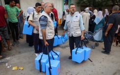 Health workers carry containers filled with Polio vaccines during a vaccination campaign in Zawayda. AFP/Eyad Baba.jpg