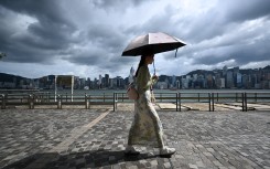 Tourists walk on the promenade at Victoria harbour in Hong Kong. AFP/Peter Parks