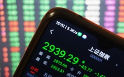 A stock owner's mobile phone shows the closing point of the Shanghai Composite Index. CFOTO/NurPhoto via AFP