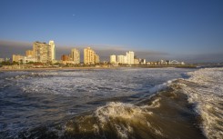 File: View of promenade, beach and hotels from pier in Indian Ocean at sunrise, Durban, KwaZulu-Natal Province, South Africa, Africa.