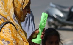 A woman is cooling off herself with a battery fan on a hot summer day in Srinagar. Firdous Nazir/NurPhoto via AFP