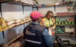 Members of the Department of Health as they conduct an inspection on a spaza shop in Naledi, Soweto. AFP/Shiraaz Mohamed