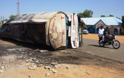 A motorcycle rides past the remain of a fuel tanker whose explosion killed almost 150 people in Majiya. AFP/Aminu Abubakar