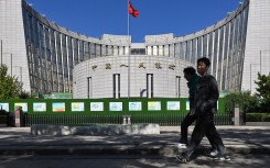 People walk past the People’s Bank of China, the country’s central bank, in Beijing. AFP/Adek Berry