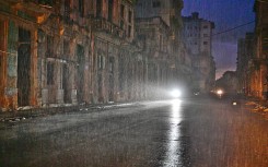 A motorcycle lights a street under pouring rain during a nationwide blackout caused by a grid failure in Havana, on October 19, 2024.