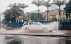 A vehicle drives through a flooded street following heavy rains. AFP/Rajesh Jantilal