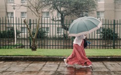 A woman walks through heavy rain in the city of Durban. AFP/Rajesh Jantilal