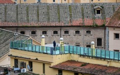 File: A prison guard (C) patrols a prison building's terrace overlooking the prison's wings, after smoke billowed from a rooftop of the Regina Coeli prison. AFP/Alberto Pizzoli