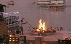 File: A cremator of the Dom community burns a funeral pyre at Harishchandra Ghat along the banks of river Ganges in Varanasi. AFP/Niharika Kulkarni