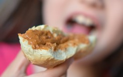 File: A girl bites into a sandwich. Hendrik Schmidt/dpa Picture-Alliance via AFP
