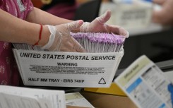 Election workers prepare mail-in ballots for tallying. AFP/Robyn Beck