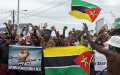 Protesters hold the Mozambican flag during a protest against the government in the Patrice Lumumba neighborhood in Maputo on November 6, 2024