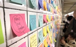 People leave post-it notes as they take part of the Subway Therapy project. AFP/Diane Desobeau