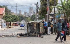People observe the rubble of a burned car in the Maxaquene neighbourhood of Maputo. AFP/Alfredo Zuniga