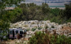 A SAPS vehicle near an opening to the mine shaft in Stilfontein. AFP/Phill Magakoe