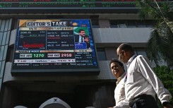 Pedestrians walk past a digital broadcast on the facade of Bombay Stock Exchange (BSE) in Mumbai. AFP/Indranil Mukherjee