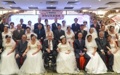 Couples posing for a group wedding photo in a restaurant in Hong Kong. AFP/Jaixin Lu
