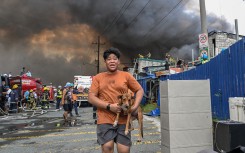 A man carries a dog during a fire at Tondo in Manila. AFP/Jam Sta Rosa