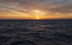 File: The sun rises over the Atlantic Ocean.