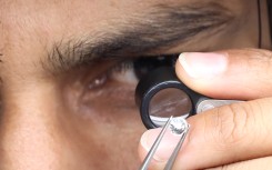 File: A supervisor checks the shape and color of a polished diamond. Rupak de Chowdhuri/NurPhoto via AFP