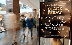 Shoppers walks past a Black Friday Sale banner at a store in a mall in Arlington, Virginia. AFP/Roberto Schmidt