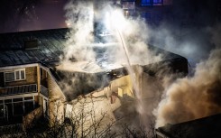 Firemen try to douse a fire following a fire and an explosion at a residential building in The Hague. AFP/Josh Walet/ANP