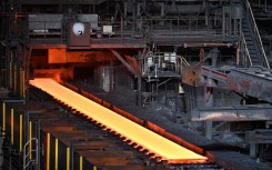 File: Steel moving along rollers at the hot rolling mill. AFP/Richard A. Brooks