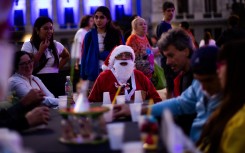 A man dressed as Santa Claus looks on as he takes part in a Christmas solidarity dinner called 'No Families Without Christmas'. AFP/Tomas Cuesta