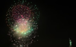 Fireworks celebrating the New Year explode in the sky above the Statue of Liberty, seen from the Red Hook district of New York, on January 1, 2025. 