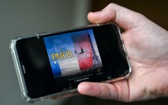 A man looks at an advert of the Pakistan International Airlines (PIA) plane flying at the Eiffel Tower. AFP/Farooq Naeem