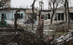 A woman stands among debris of her heavily damaged residential building in the town of Lyman. AFP/Genya Savilov